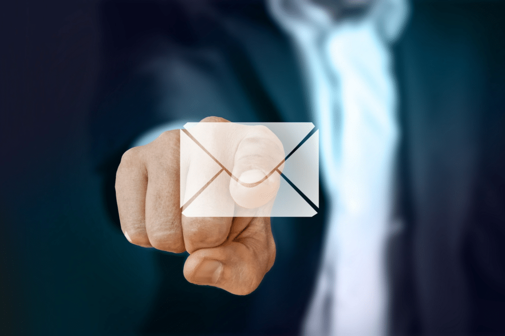 Man in suit pointing to email icon on screen